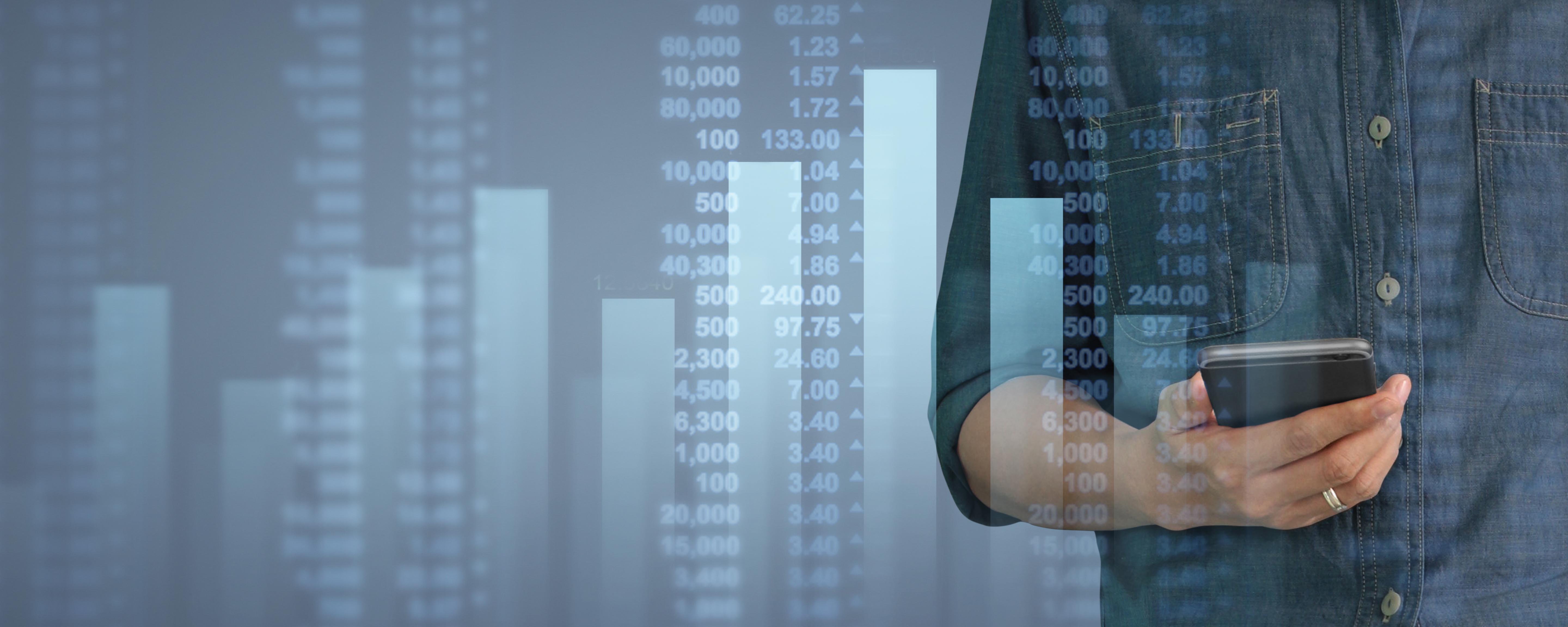 En mannlig kontorarbeider ser på lønnsstatistikk på mobilen sin, statistikken er fremstilt i søylediagram som vises i forgrunnen.