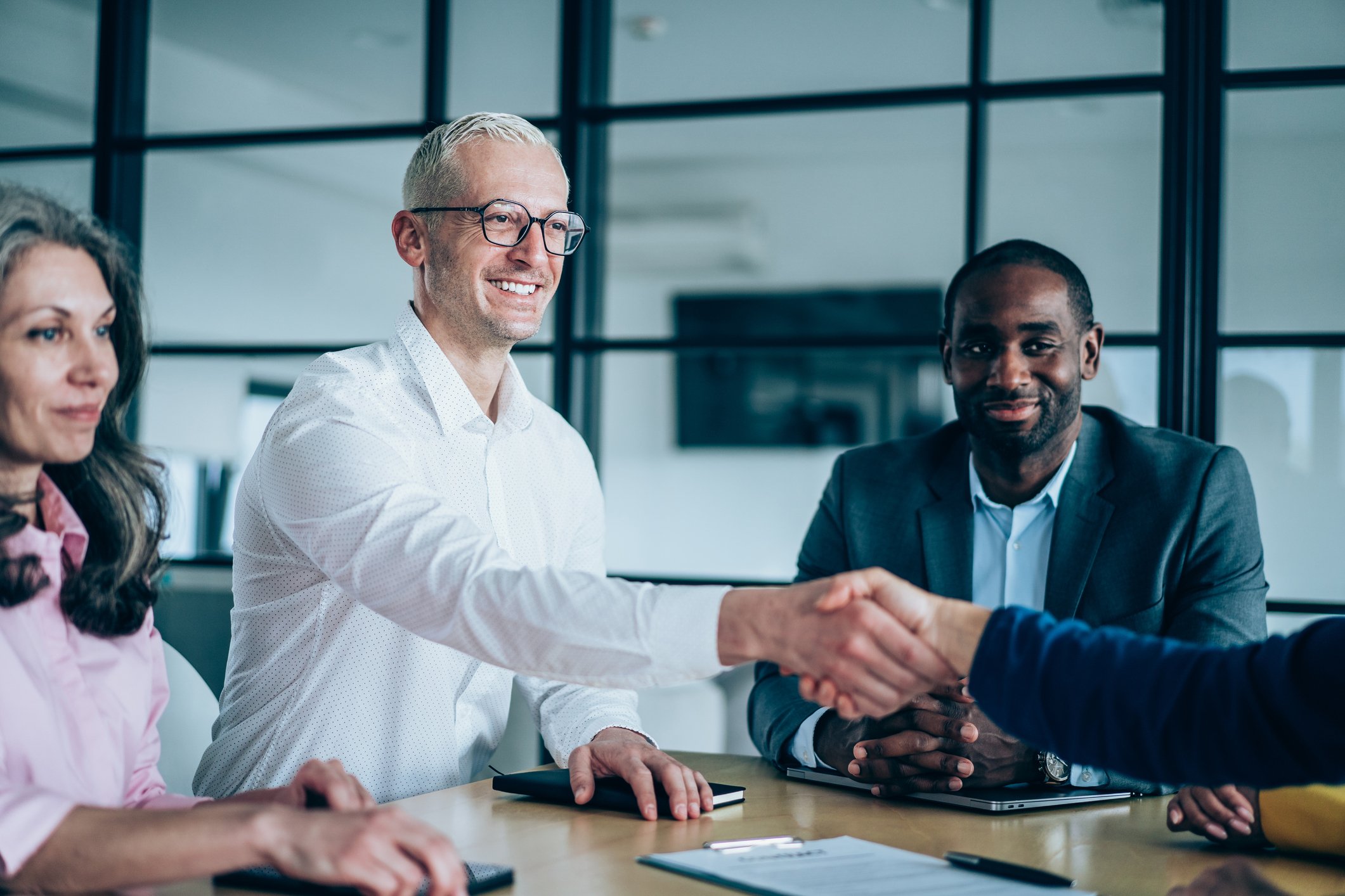 En mann som håndhilser på en annen person.