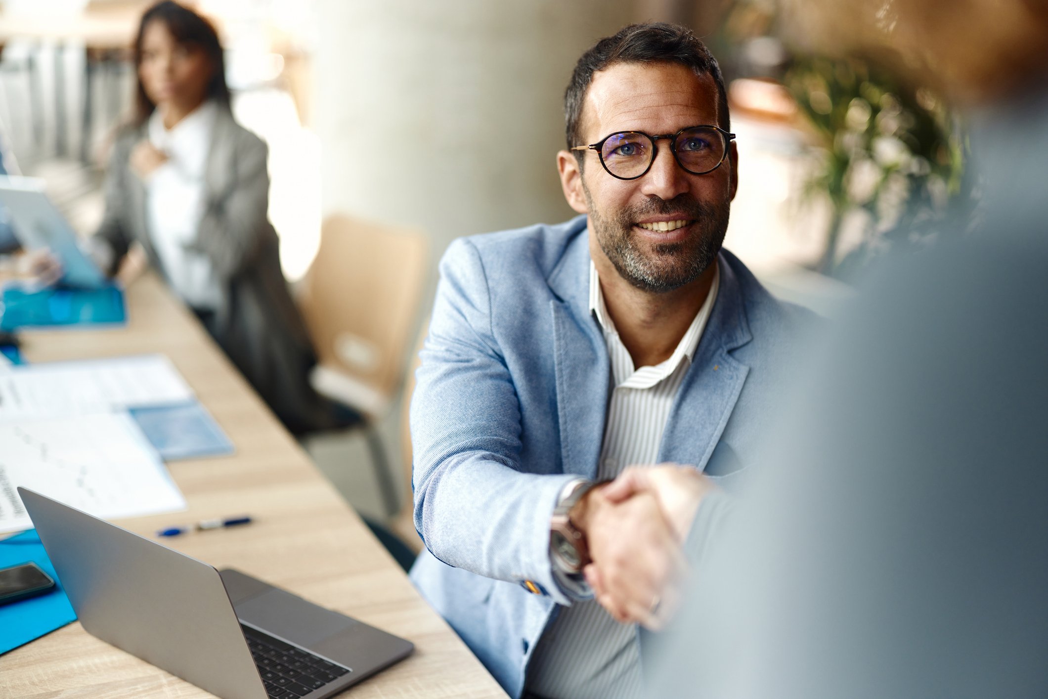 En mann som håndhilser på en annen person.