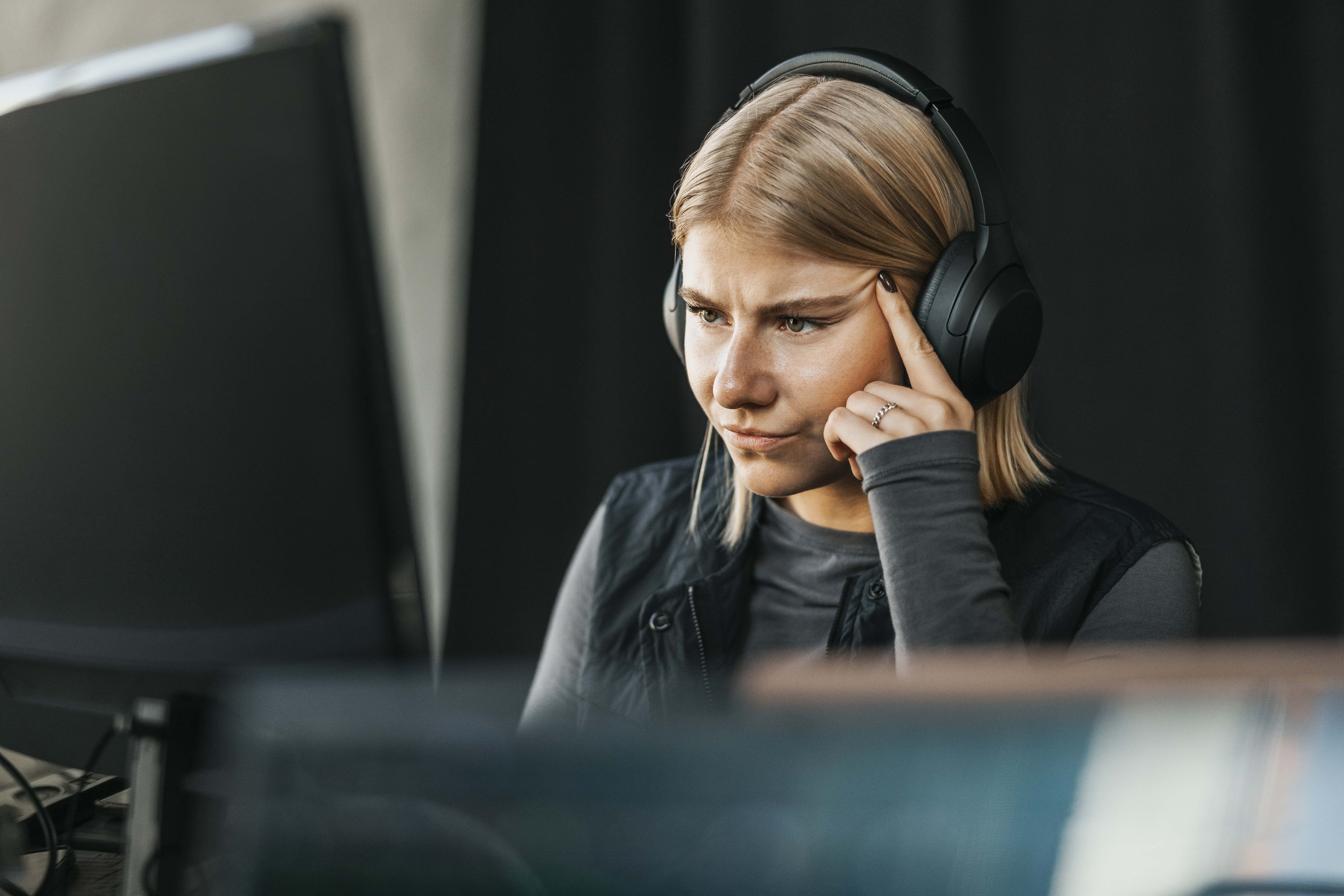 Ung dame som ser på en PC og har på headset