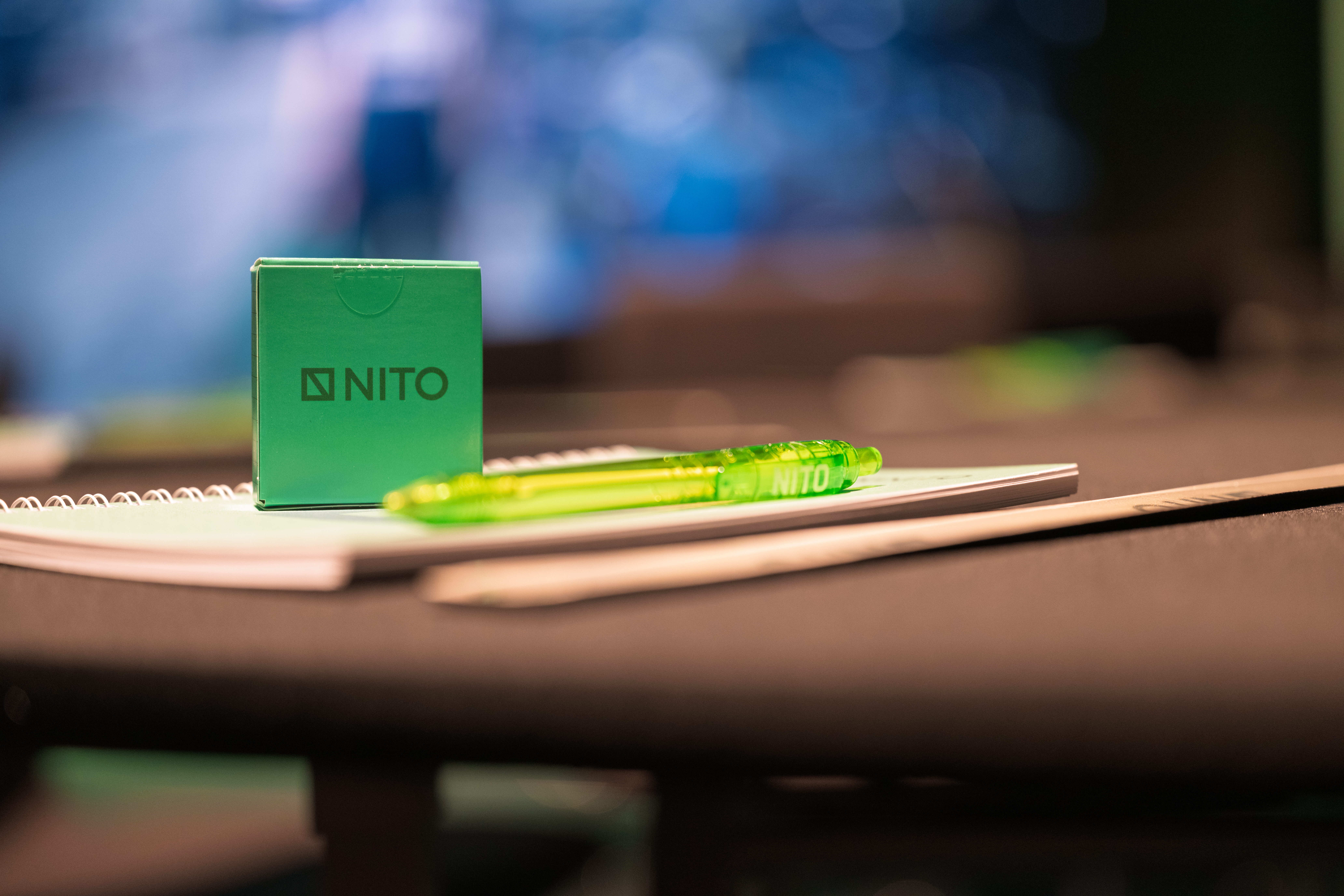 Pastilleeske og penn med logo liggende på en notatblokk