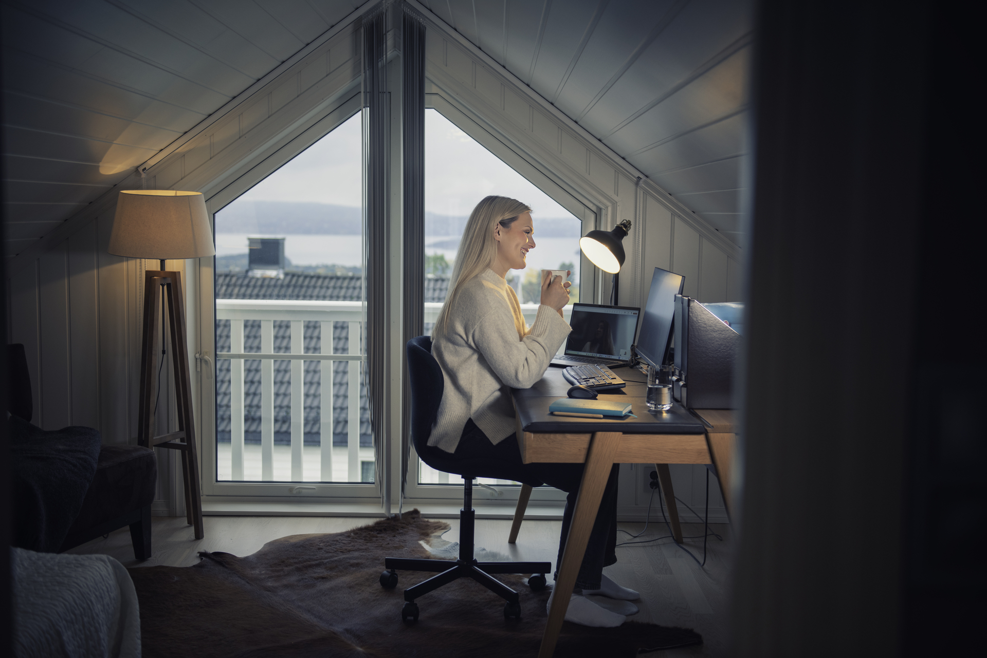 Female engineer in a home office with an ergonomic workplace in a bright attic room.