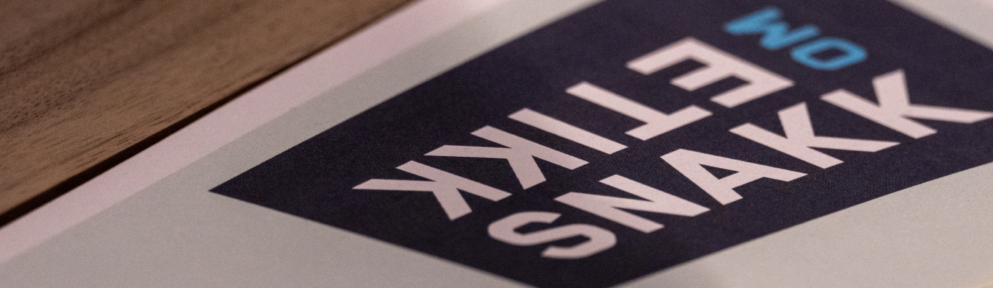 Papir med blå og gule post-it lapper, teksten "Snakk om etikk" er tydelig, bakgrunn av trebord.