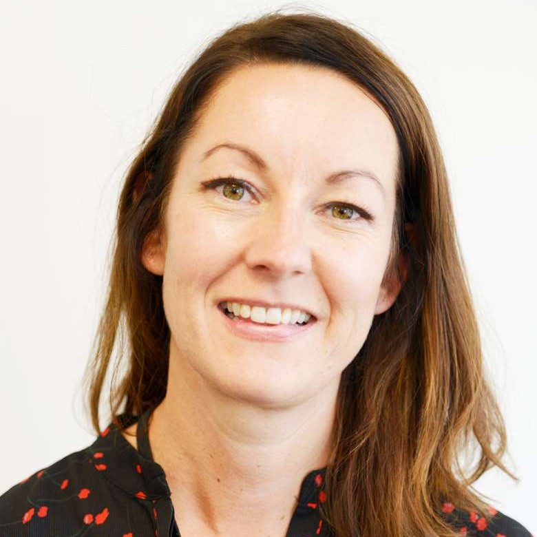 Portrait of smiling woman with long dark hair.