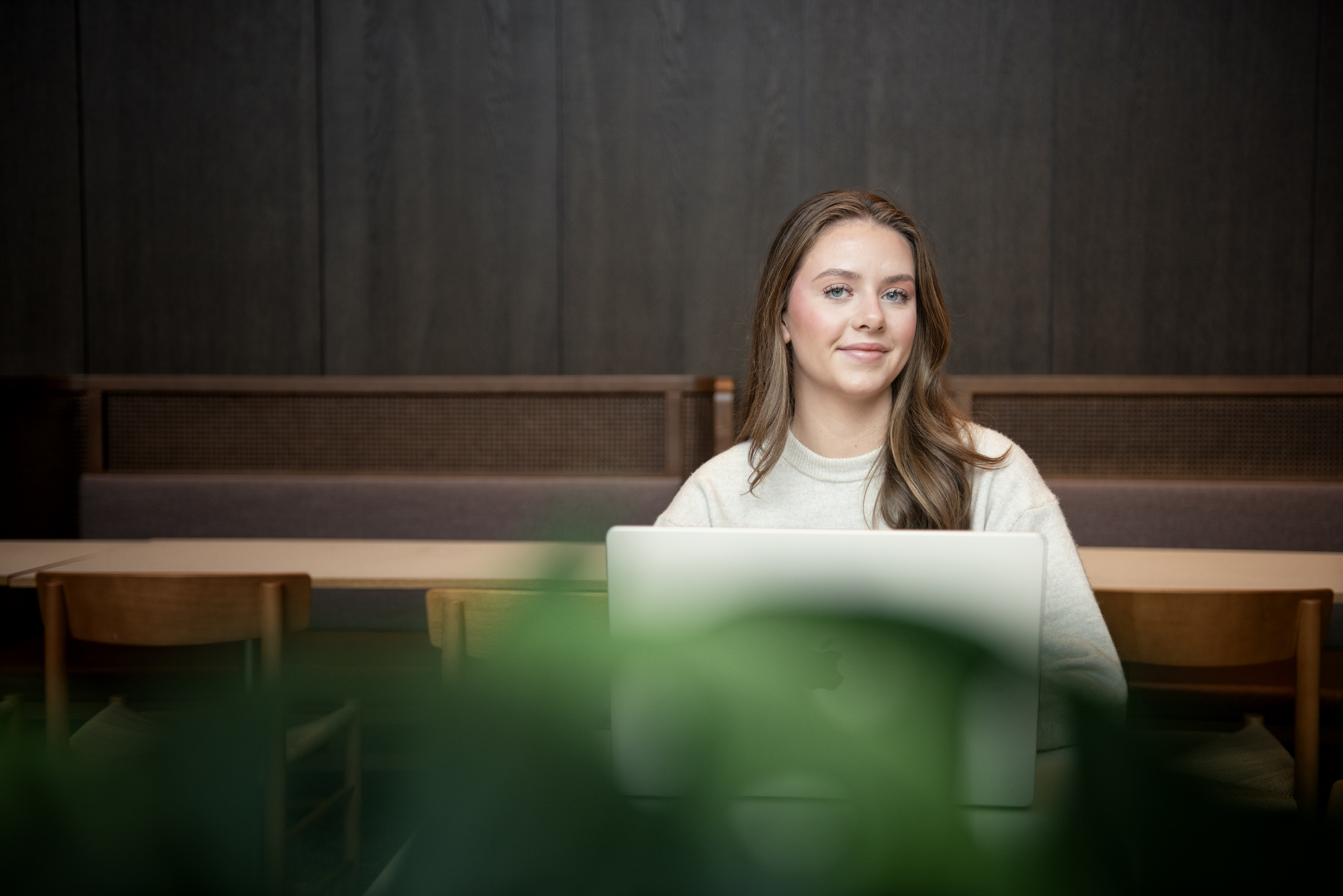 Ung dame sitter foran PC i et klasserom