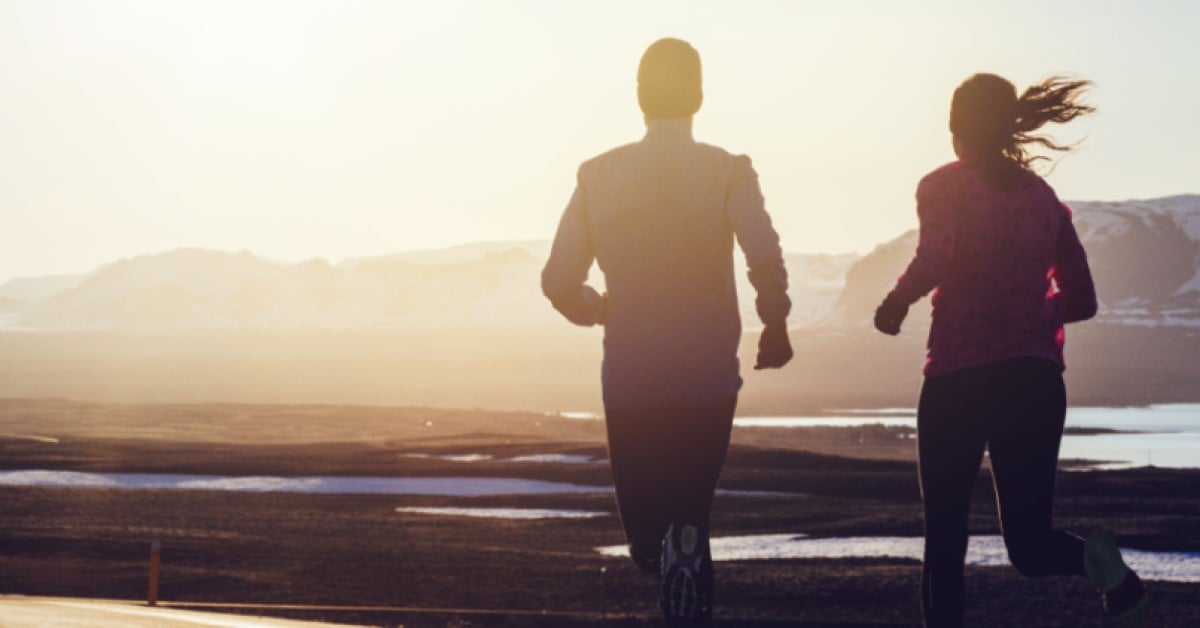 Two people running at sunset.