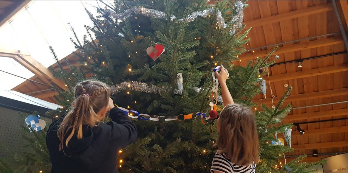 En jente som pynter juletre