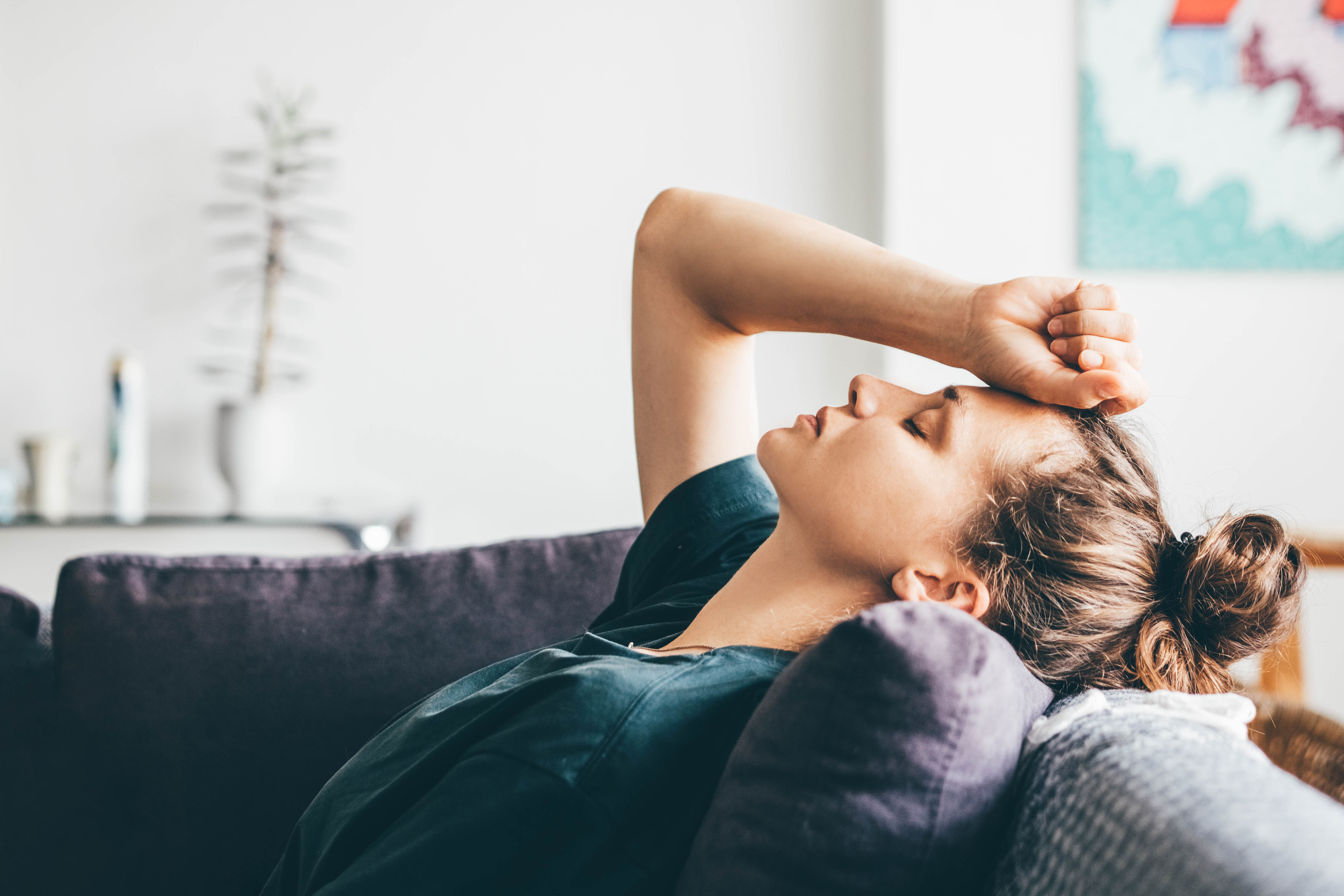 Sliten kvinne som ligger på en sofa
