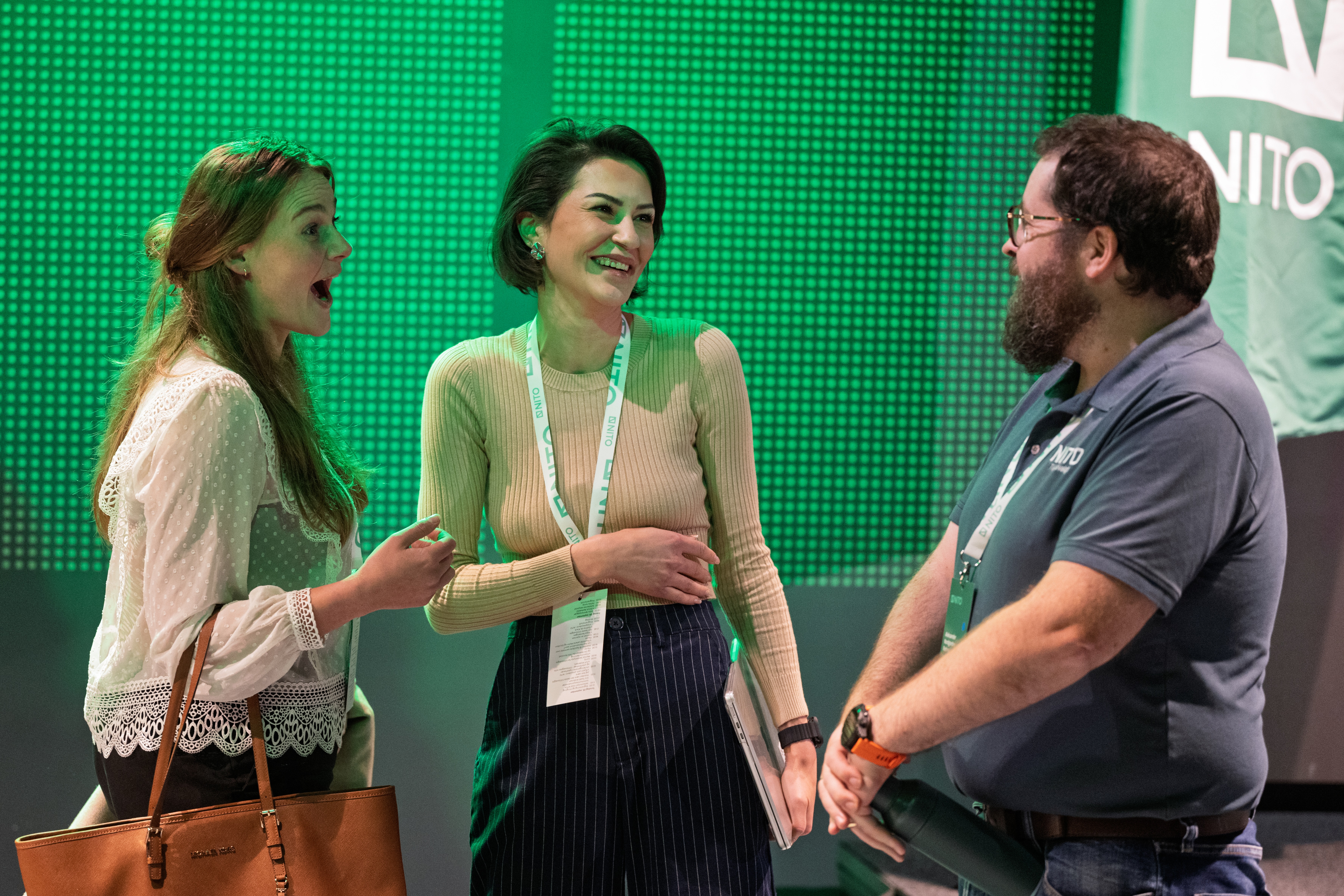 Tre tillitsvalgte står å snakker sammen mens de ler og smiler