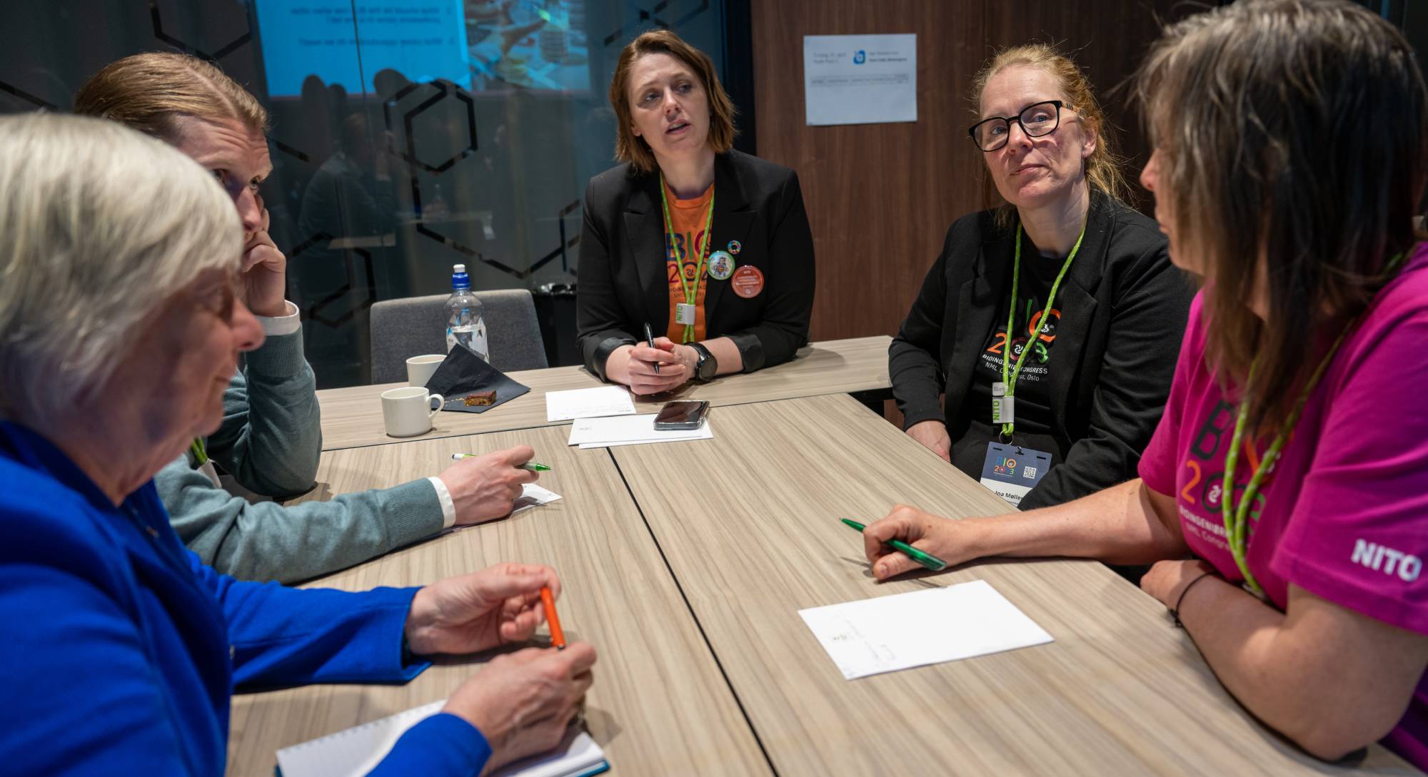 Fem kvinner som sitter rundt et bord og har en faglig diskusjon