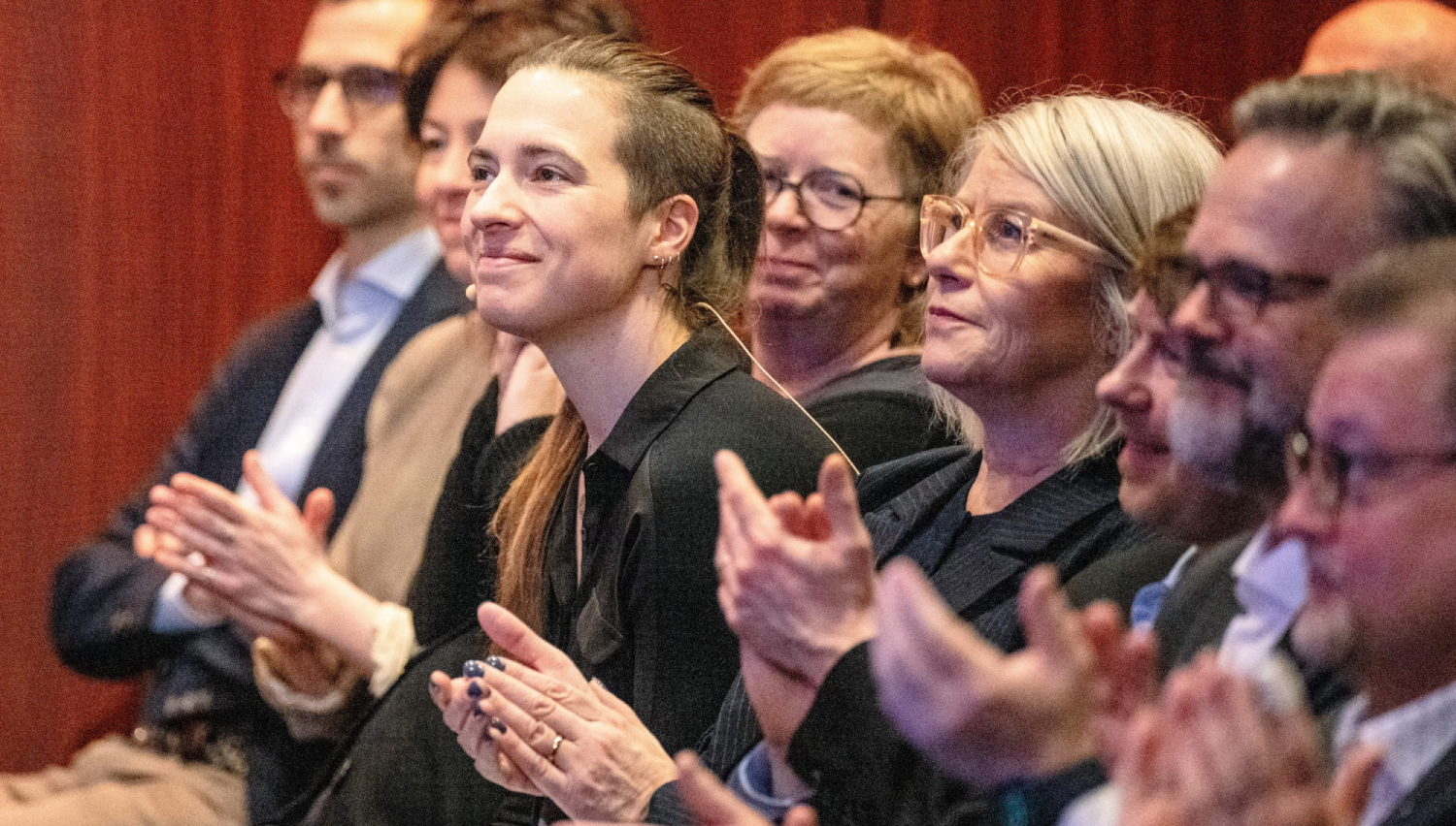 Applauderende tilhørere i en konferansesal