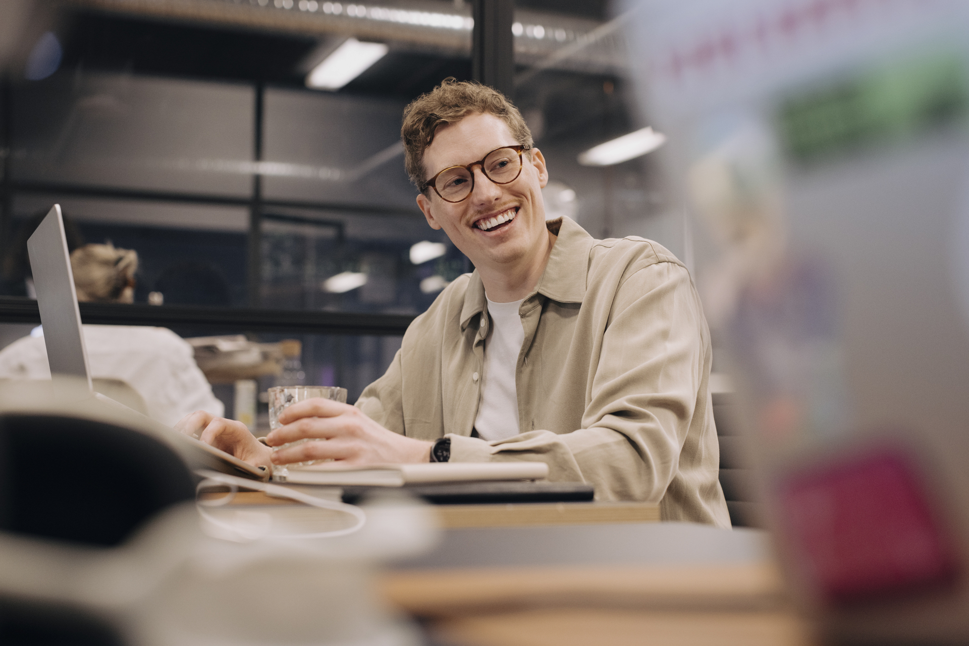 Ung mann med briller ved laptop