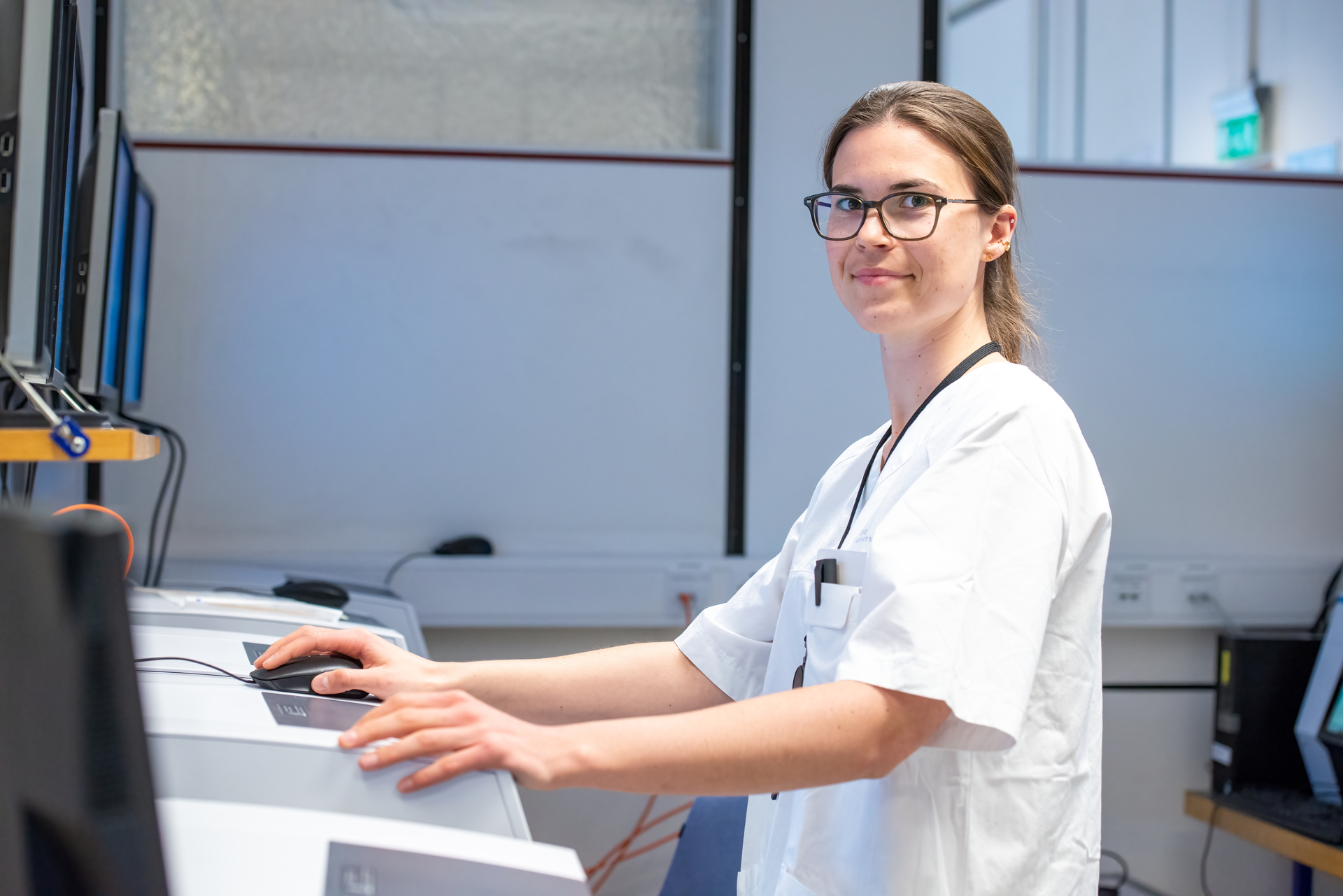 Bioingeniør i hvit laboratoriumsfrakk arbeider med avansert laboratoriumsutstyr. Illustrerer arbeidsforhold og bioingeniørlønn i Norge.