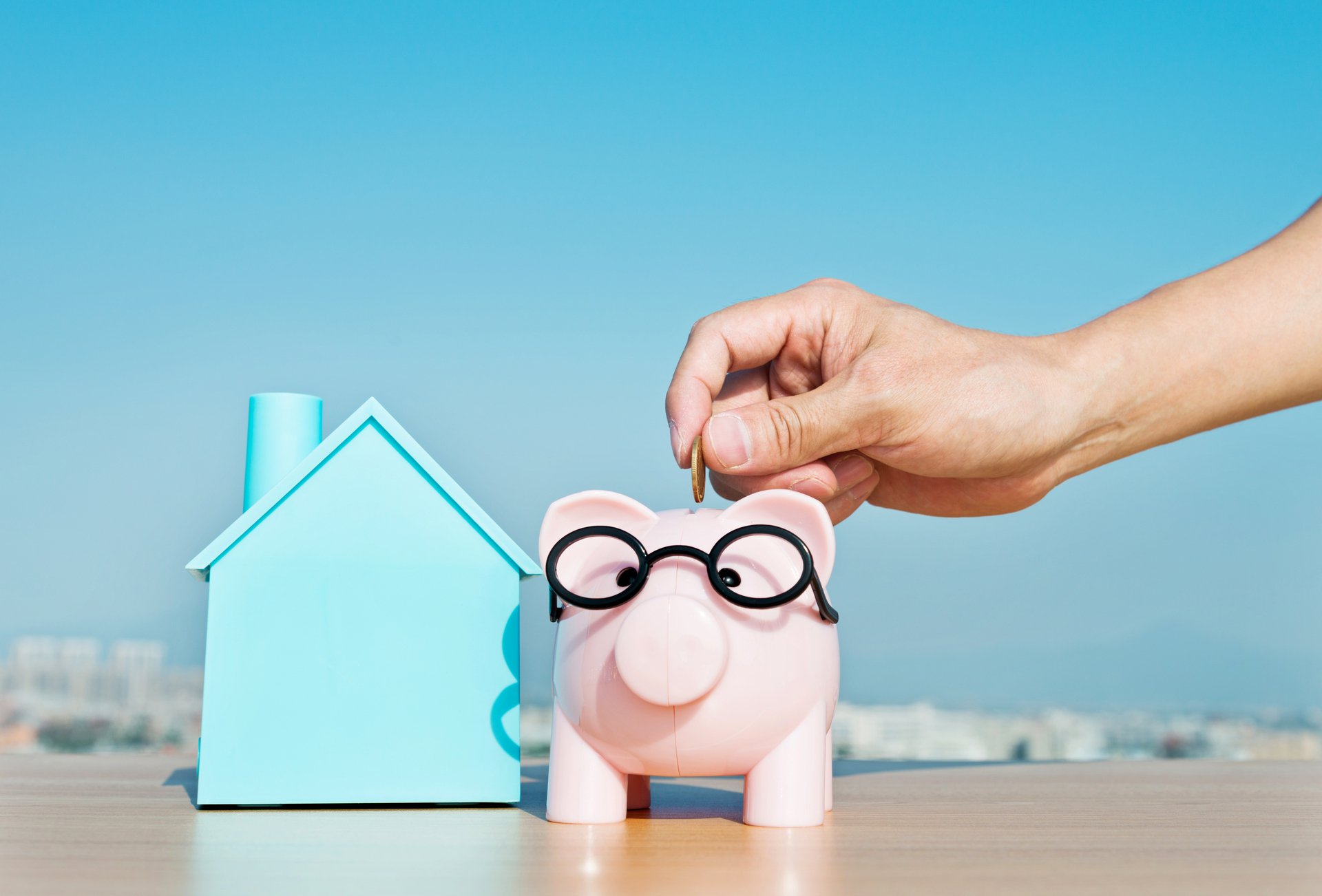 Illustrasjonsbilde av noen som putter penger på en sparegris