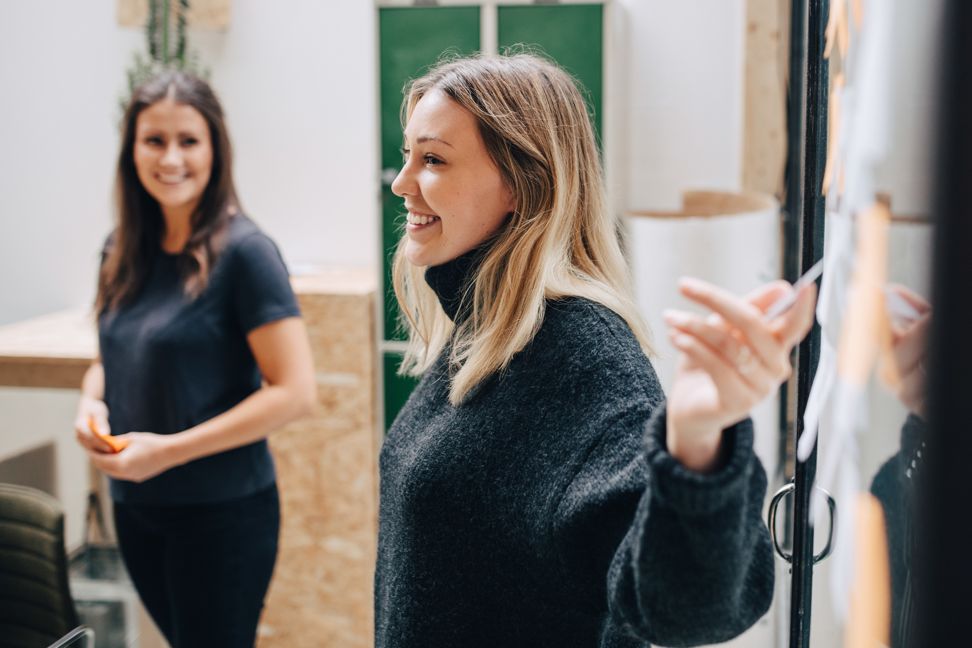 Smilende forretningskvinne forklarer strategi for lønnssamtale med sine kollegaer. Viser viktigheten av samarbeid i lønnsforhandlingene.