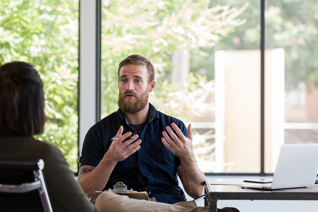 Mann og dame i samtale inne på møterom