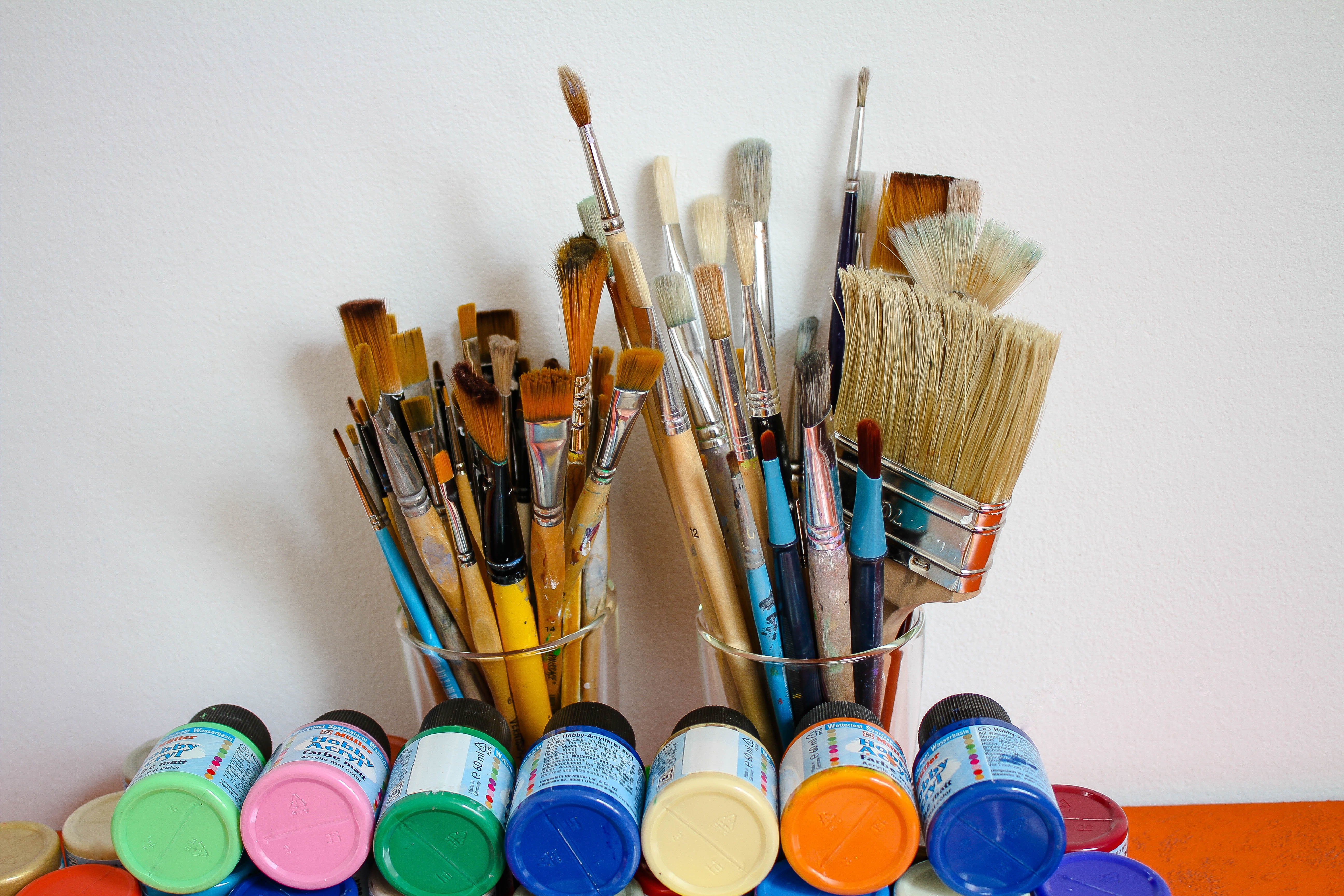 Bilde av malepensler og flasker med maling i ulike farger. Foto: Pixabay