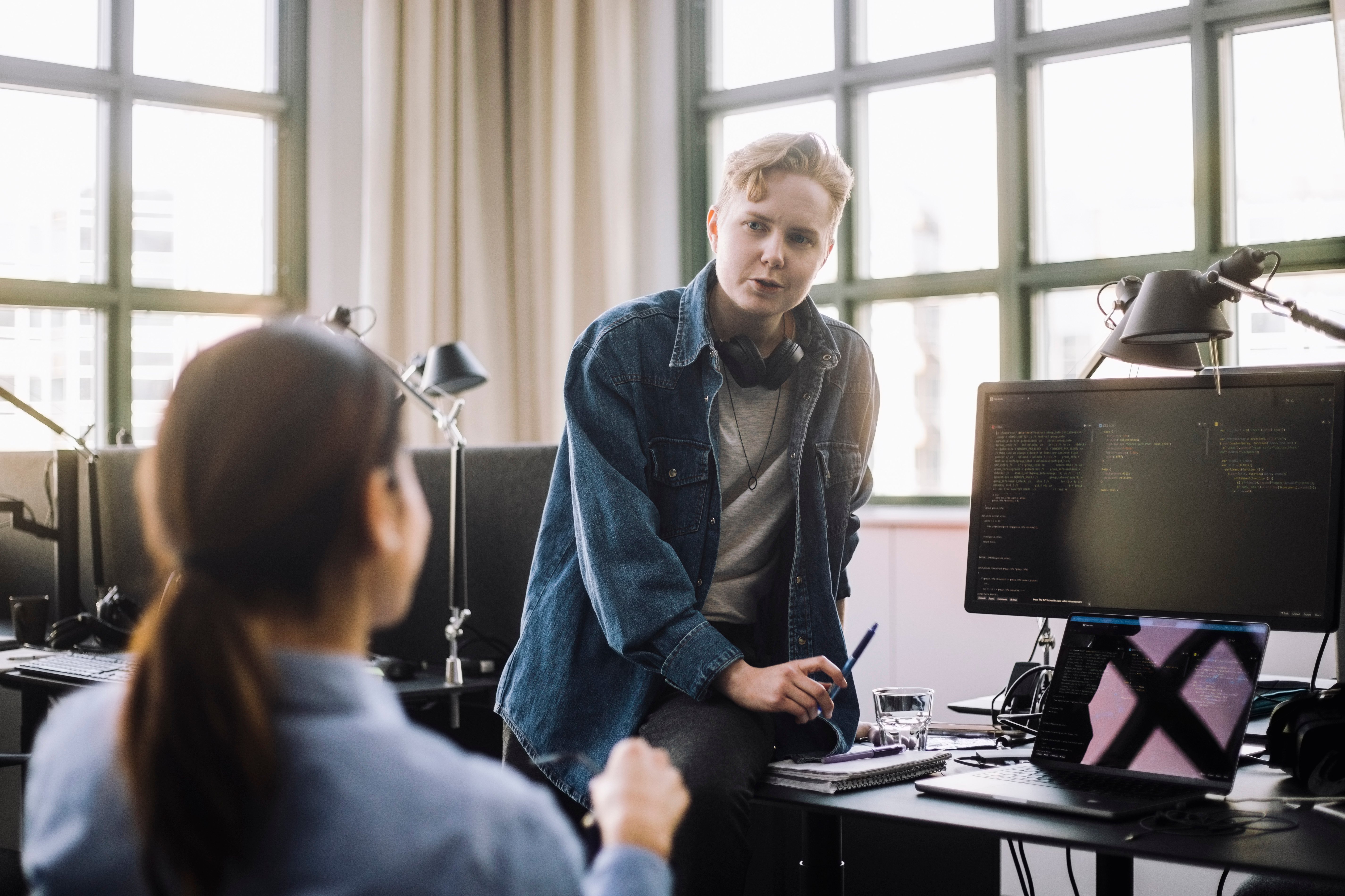 En tillitsvalgt og et medlem i samtale ved et kontorbord, symboliserer NITO som støtte og rådgiver på arbeidsplassen.