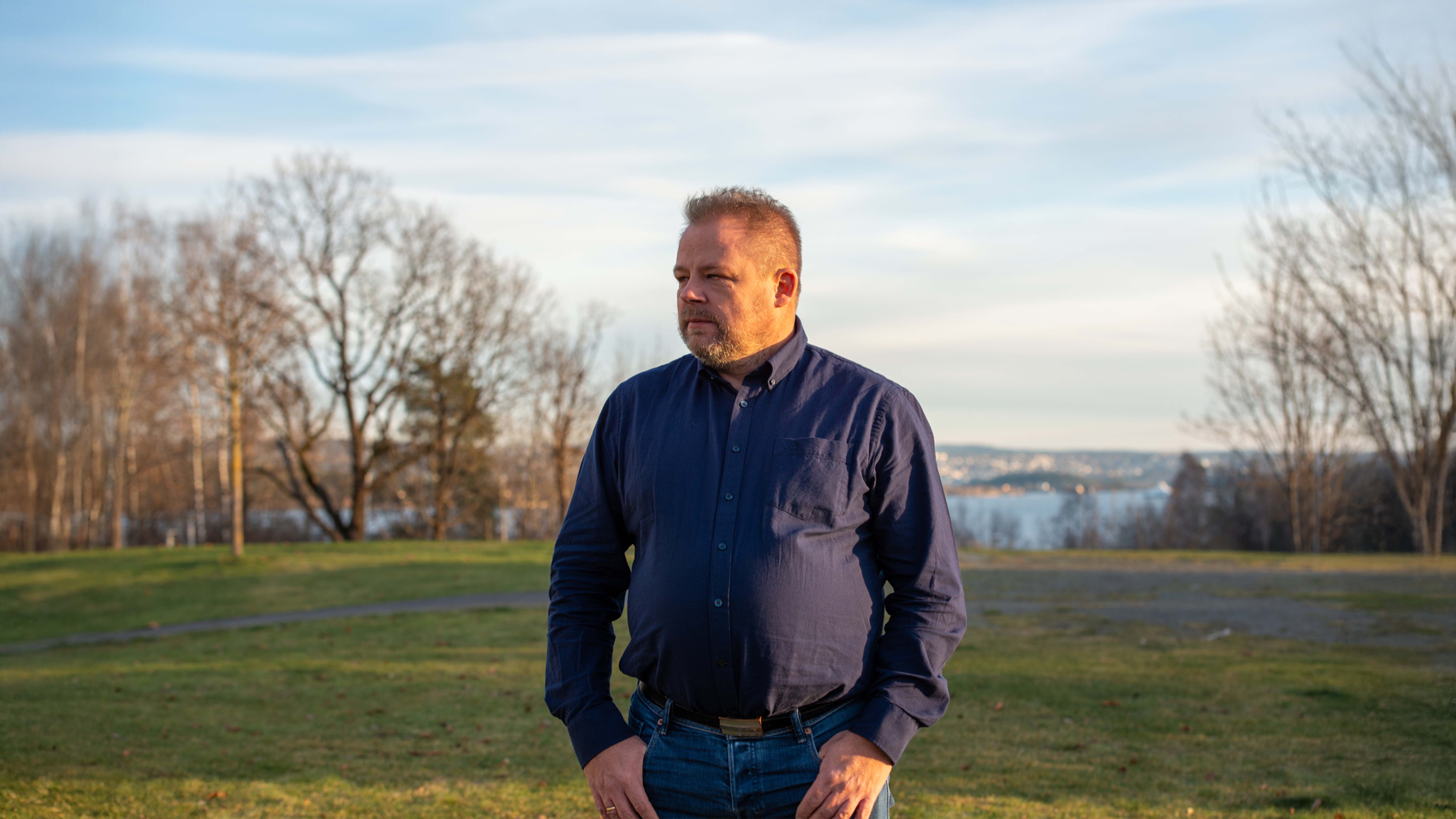 Eddy Nynes i blå skjorte ser ut over landskap.