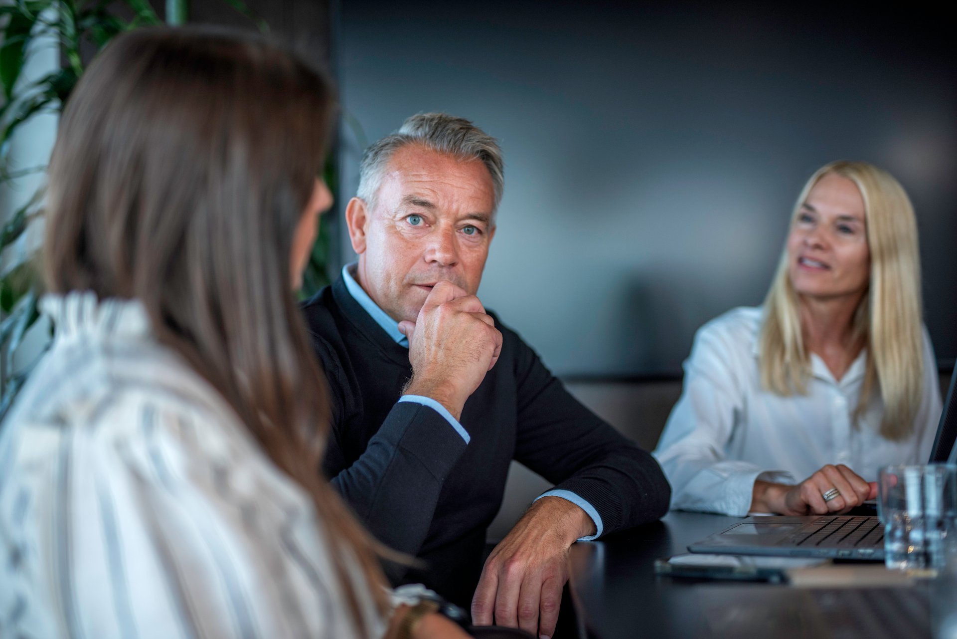 Tre personer i et møte, som representerer et medlem i samtale med sin tillitsvalgte og en annen part, i forbindelse med nedbemanning eller omstilling.