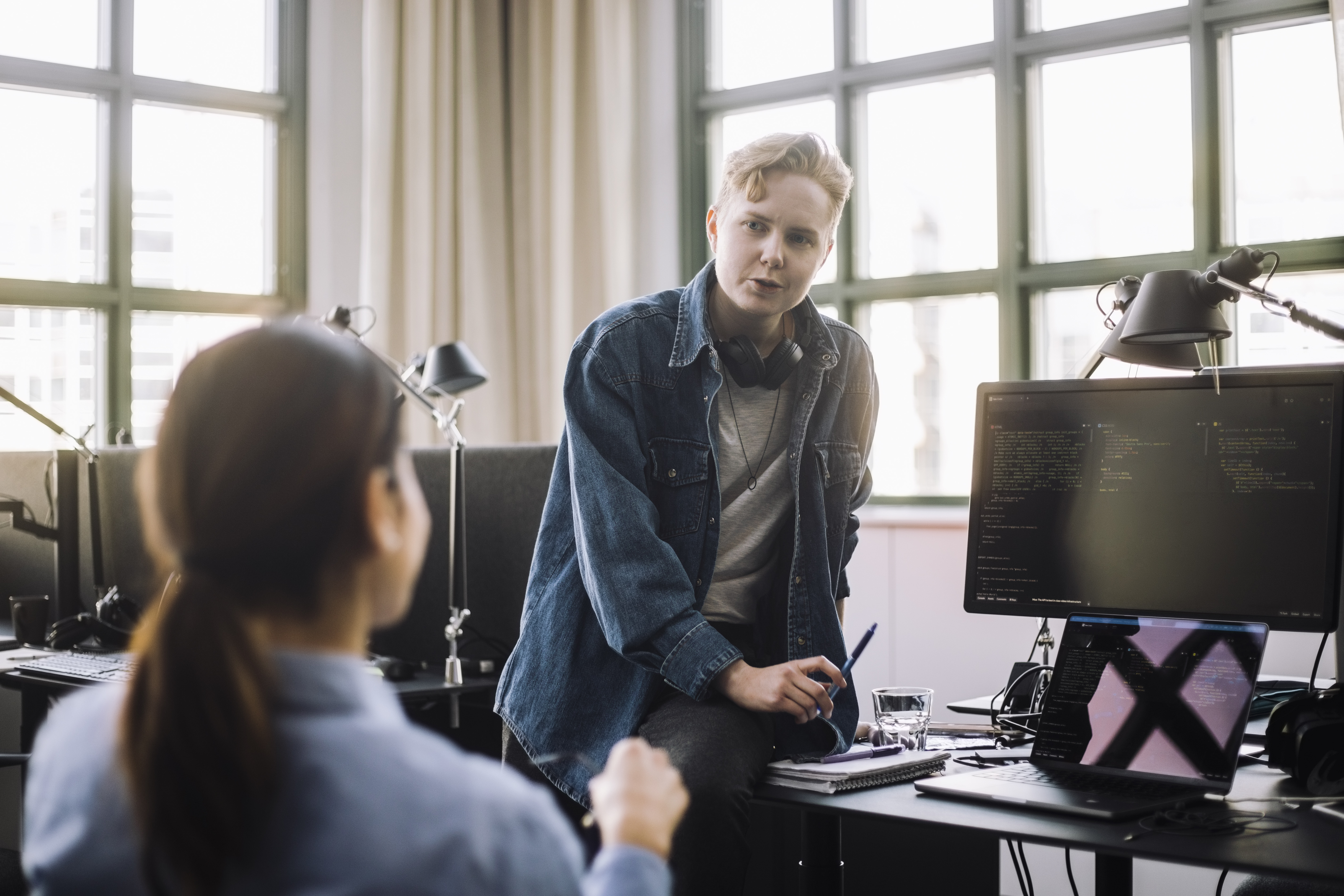 En tillitsvalgt og et medlem i samtale ved et kontorbord, symboliserer NITO som støtte og rådgiver på arbeidsplassen.