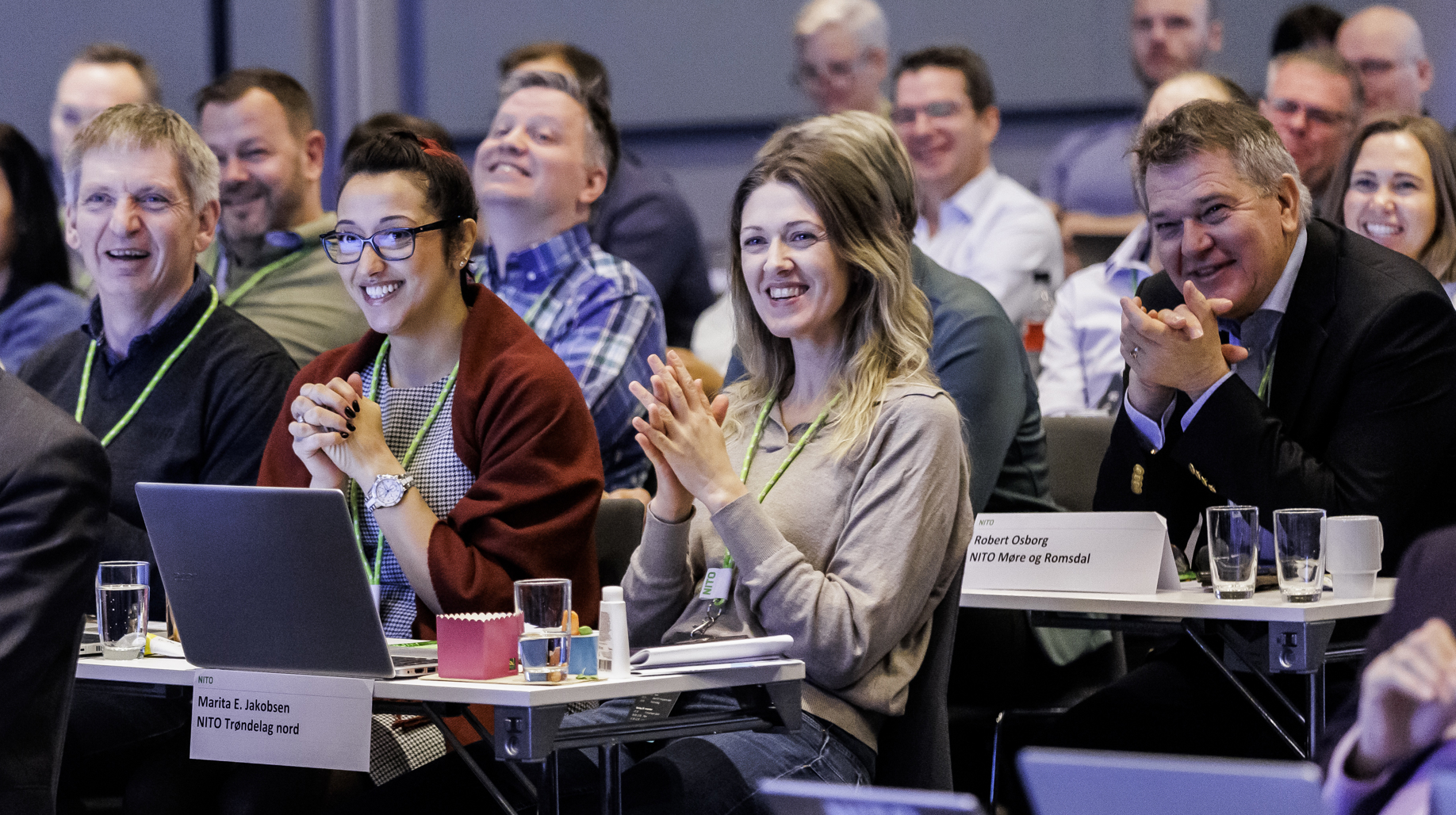 Engasjerte tillitsvalgte fra NITO applauderer på en sentral tariffkonferanse, klare for årets lønnsoppgjør.