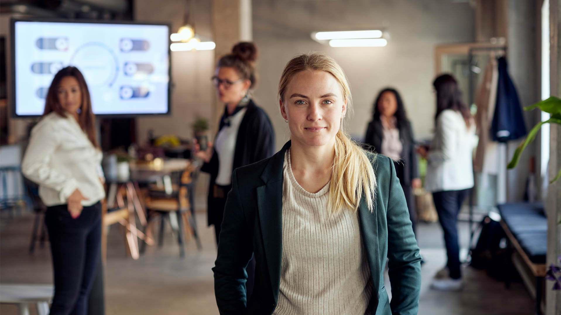 Gruppe av kvinnelige tillitsvalgte i møterom, en ser smilende i kamera, klare for å diskutere lønnspolitikk og forhandlingsstrategi.