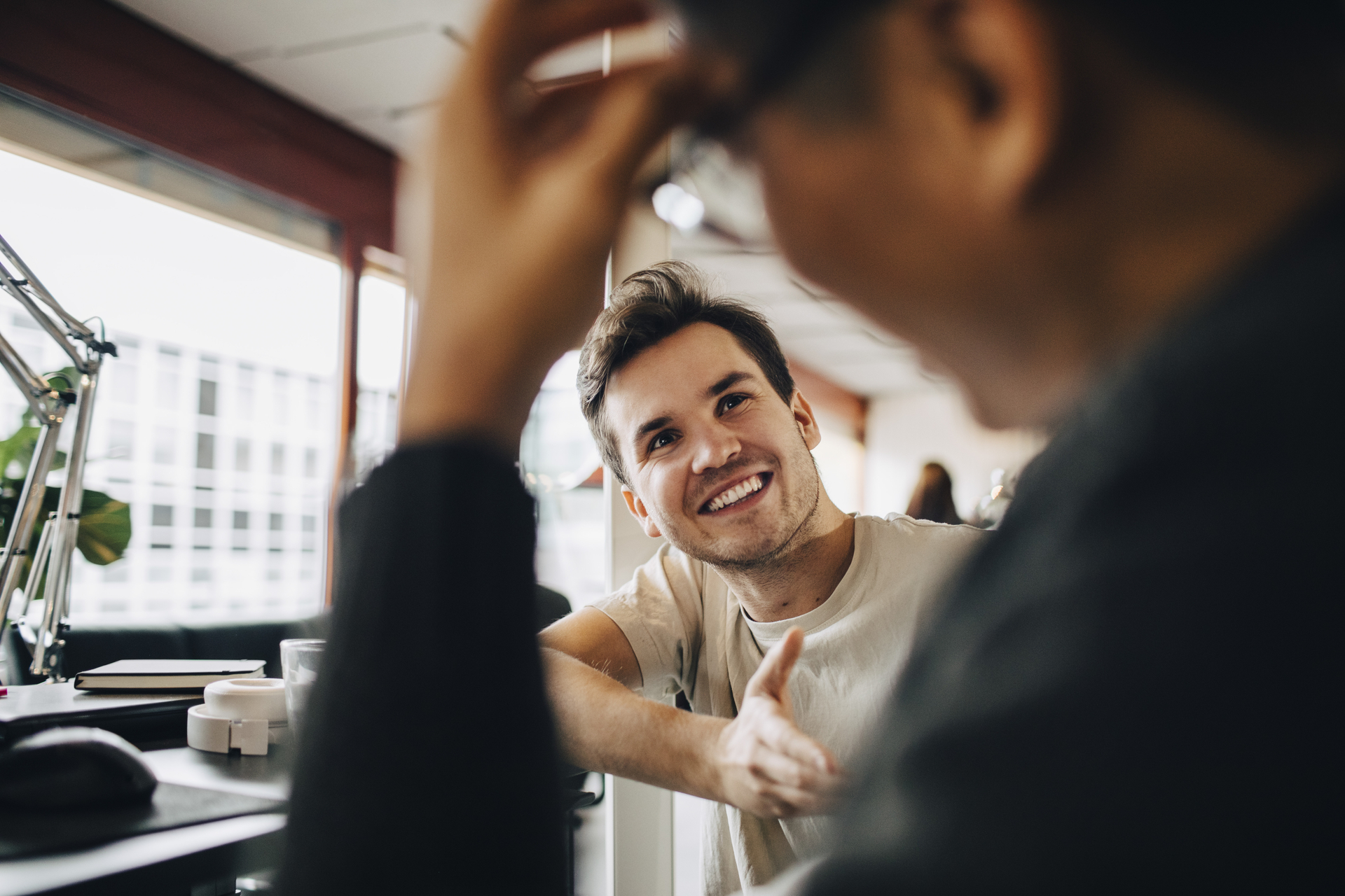 To NITO-medlemmer i lønnssamtale på et moderne kontor. De sitter ved et skrivebord med laptop og diskuterer lønn med utgangspunkt i NITOs lønnsstatistikk.
