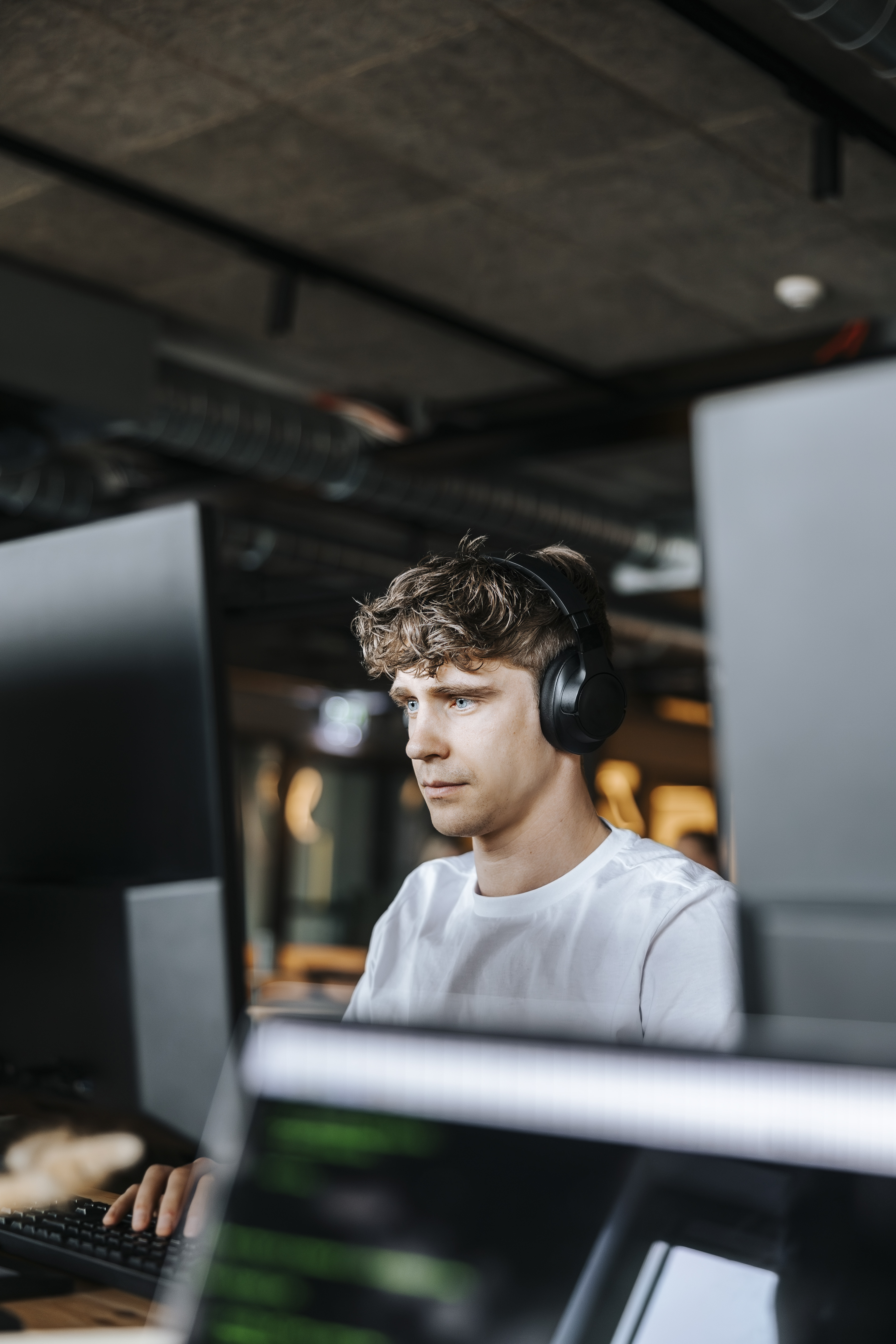 Person som sitter foran PC med headset.